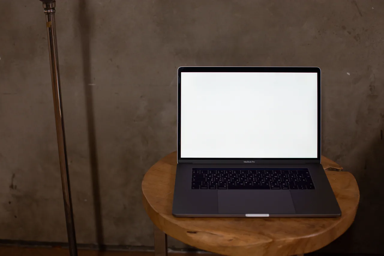 A laptop on a wooden stool in a workshop corner