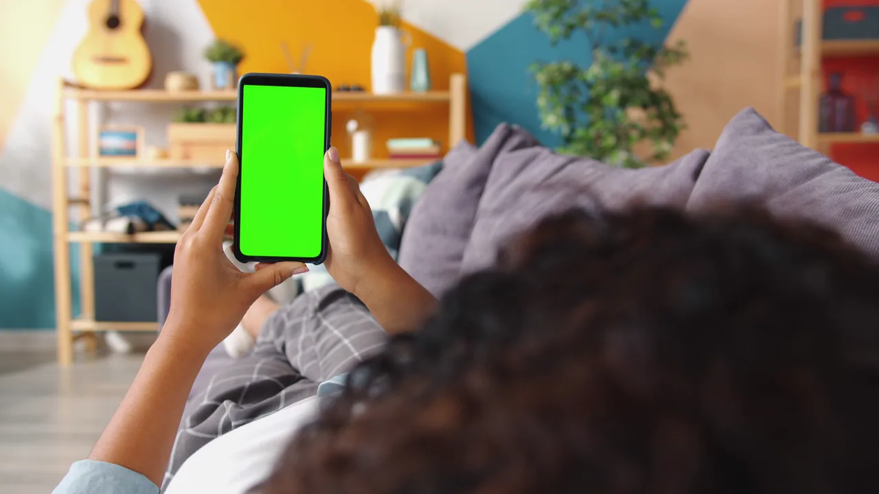 A homeowner on the sofa holding a phone