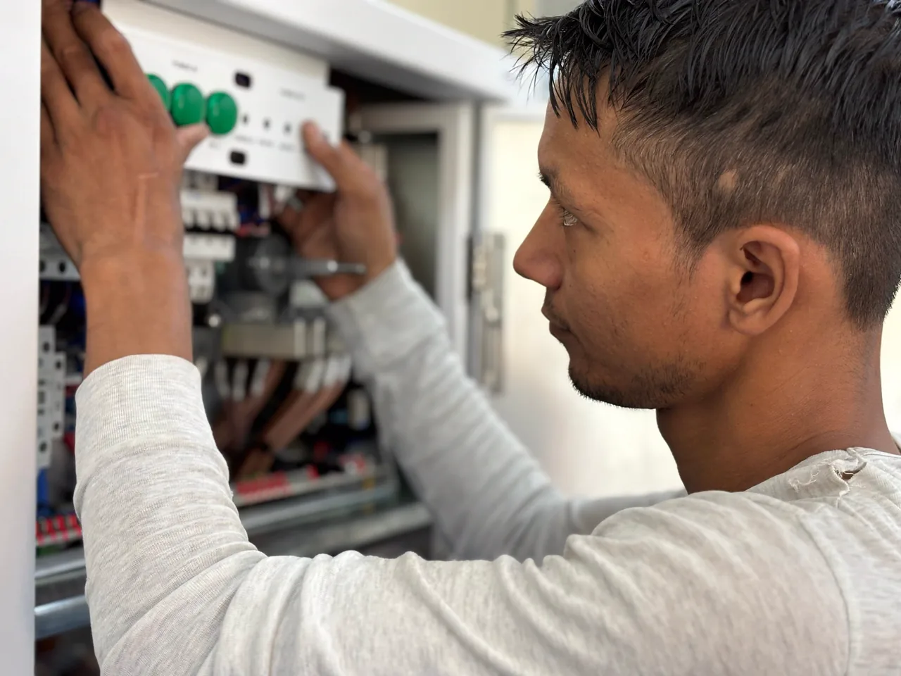 An electrician fitting the cover onto a home's electrical panel